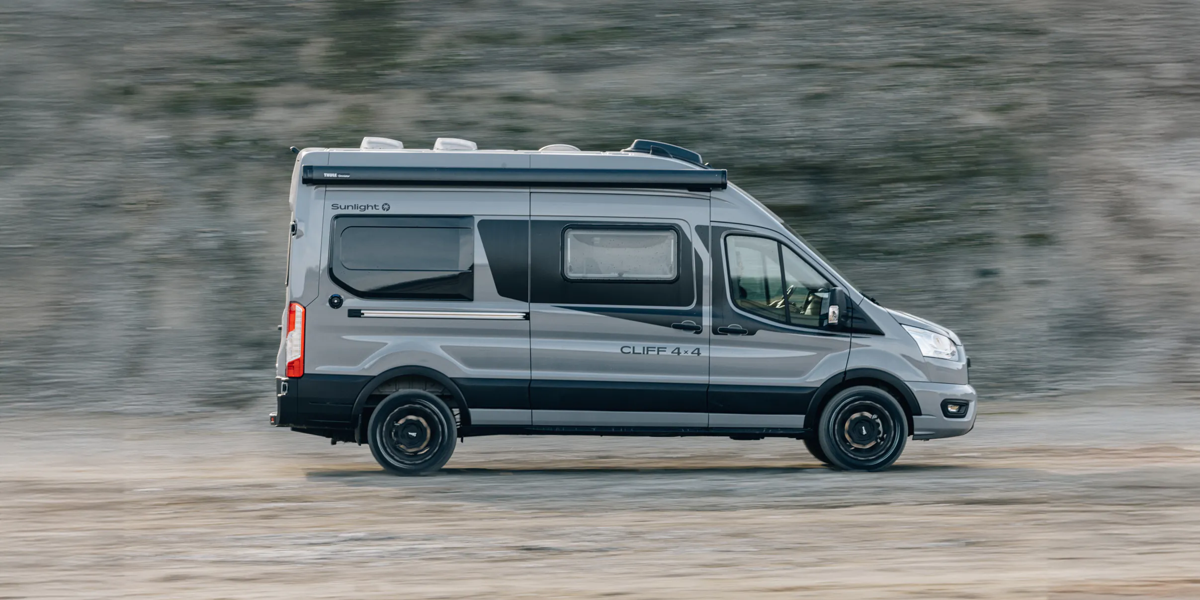 Ein Sunlight Cliff 4x4 Campervan fährt auf einer unbefestigten Straße.