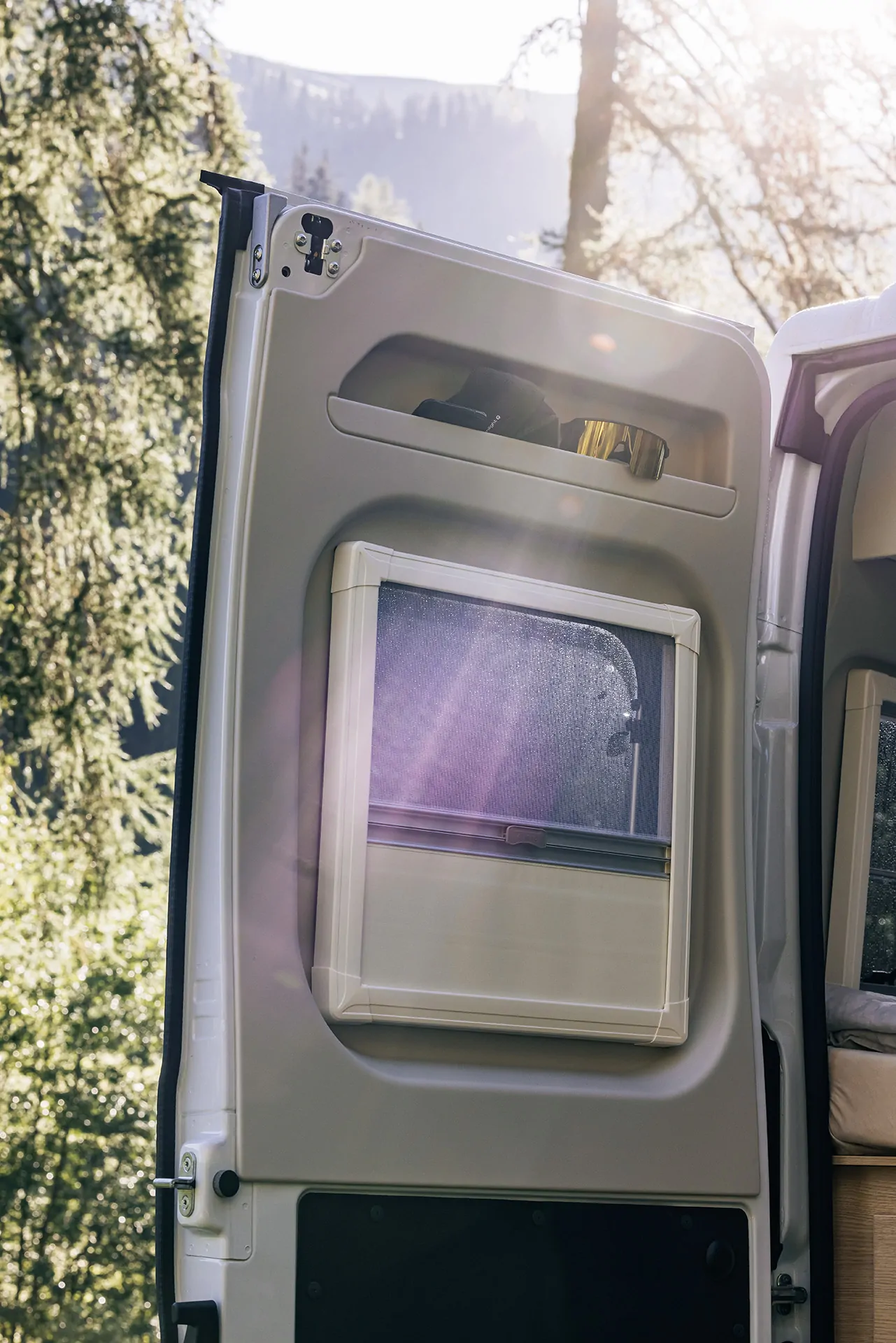 Wohnmobil Sunlight Cliff mit geöffneter Tür und Fenster im Sonnenlicht.