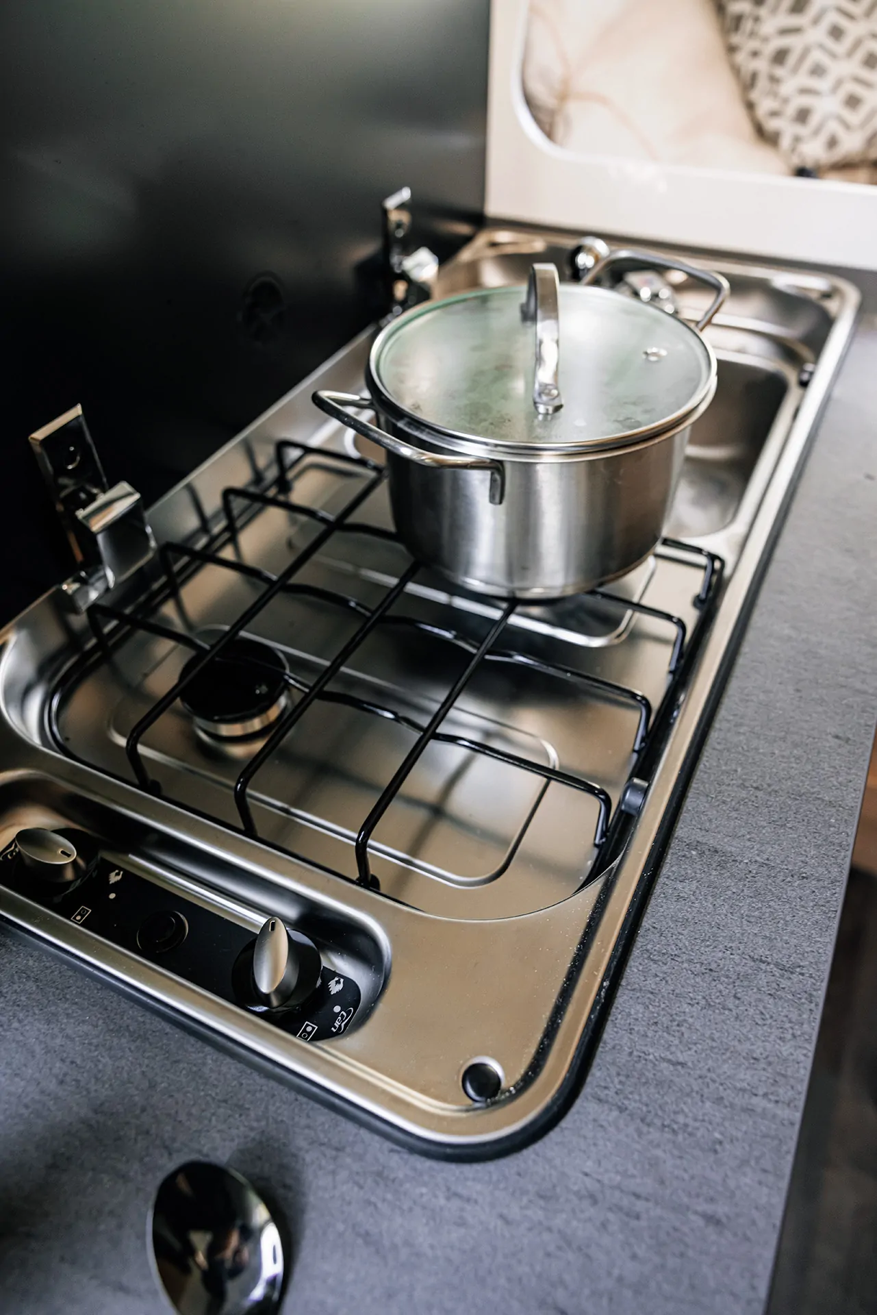 Ein Topf steht auf einem zweiflammigen Gaskocher im Sunlight Cliff Camper.