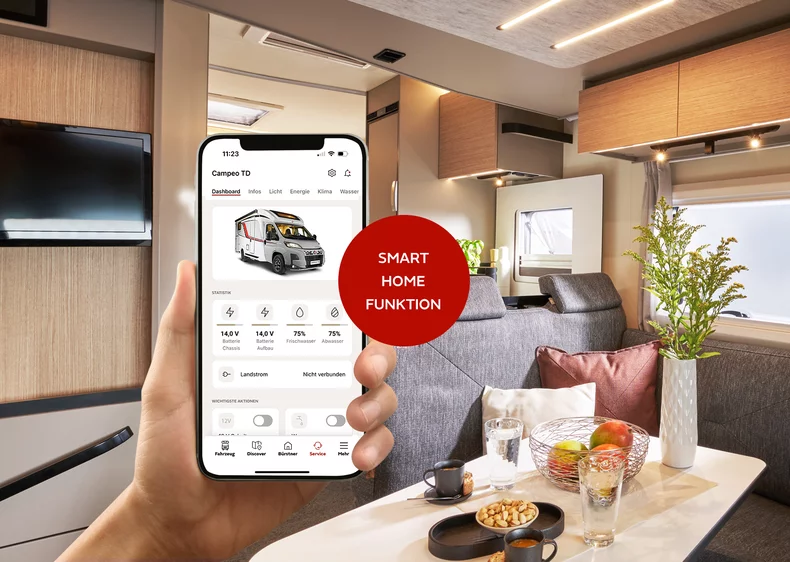 Eine Hand hält ein Smartphone mit der My Bürstner App in einem Camper-Wohnbereich.