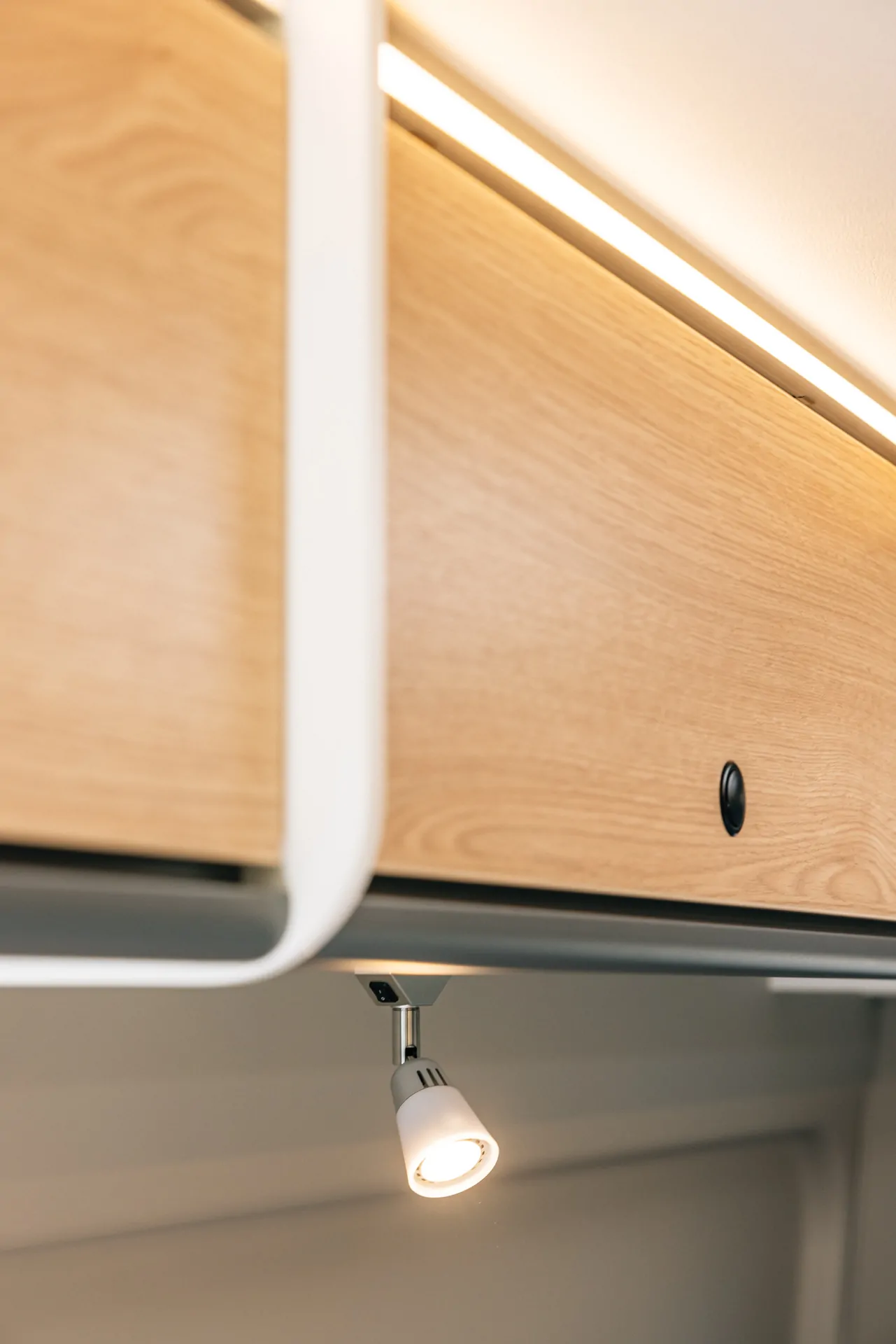 Holzschrank mit integrierter LED-Leuchte in einem Camper.