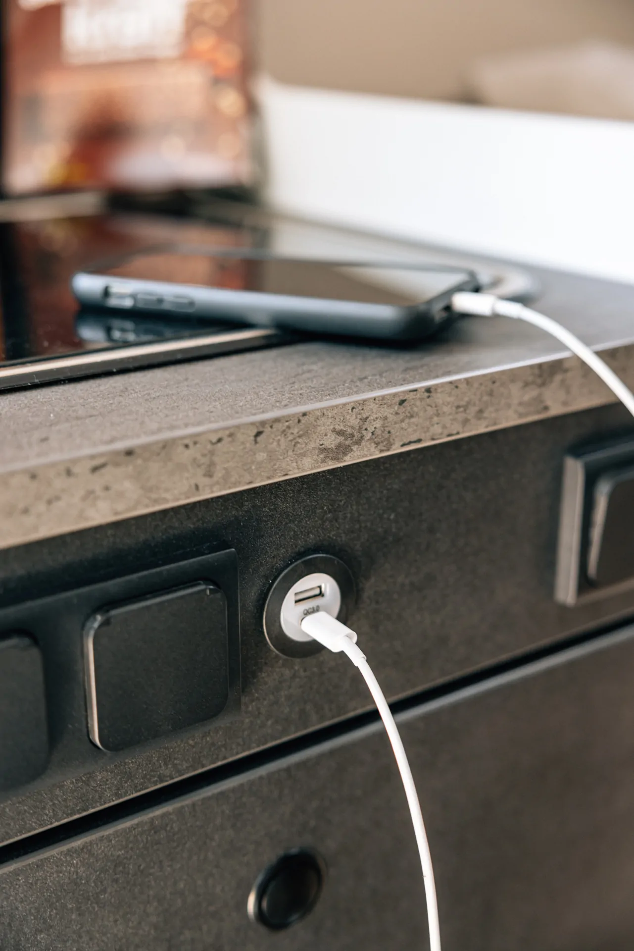 Ein Smartphone wird über ein USB-Kabel an eine Steckdose angeschlossen.