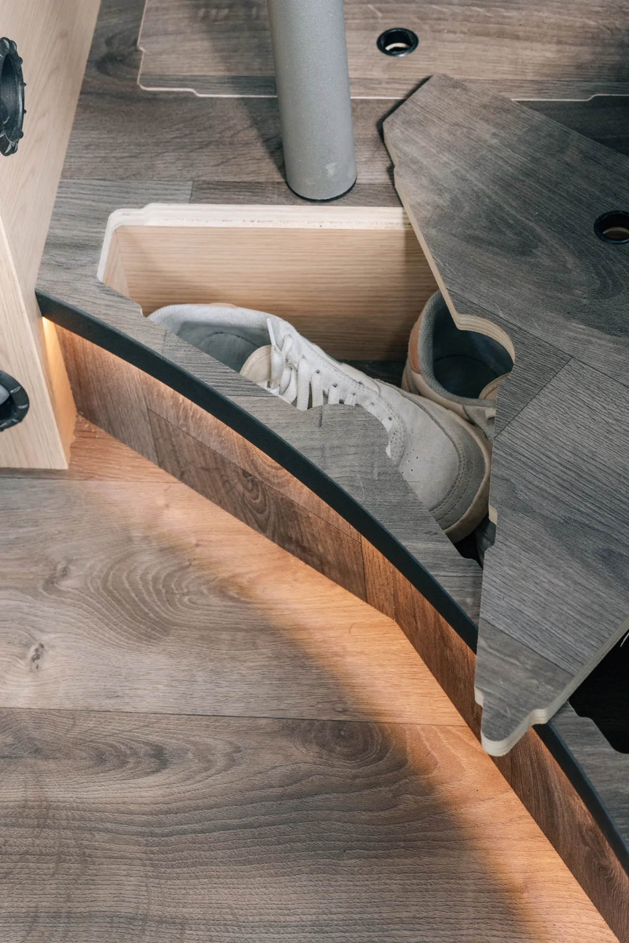 Ein Schuhfach in einem Camper mit einem weißen Sneaker darin.