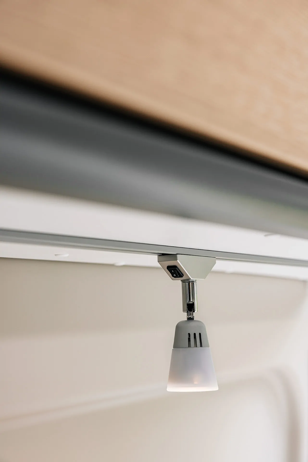 Eine kleine, moderne Innenleuchte hängt unter einem Schrank.