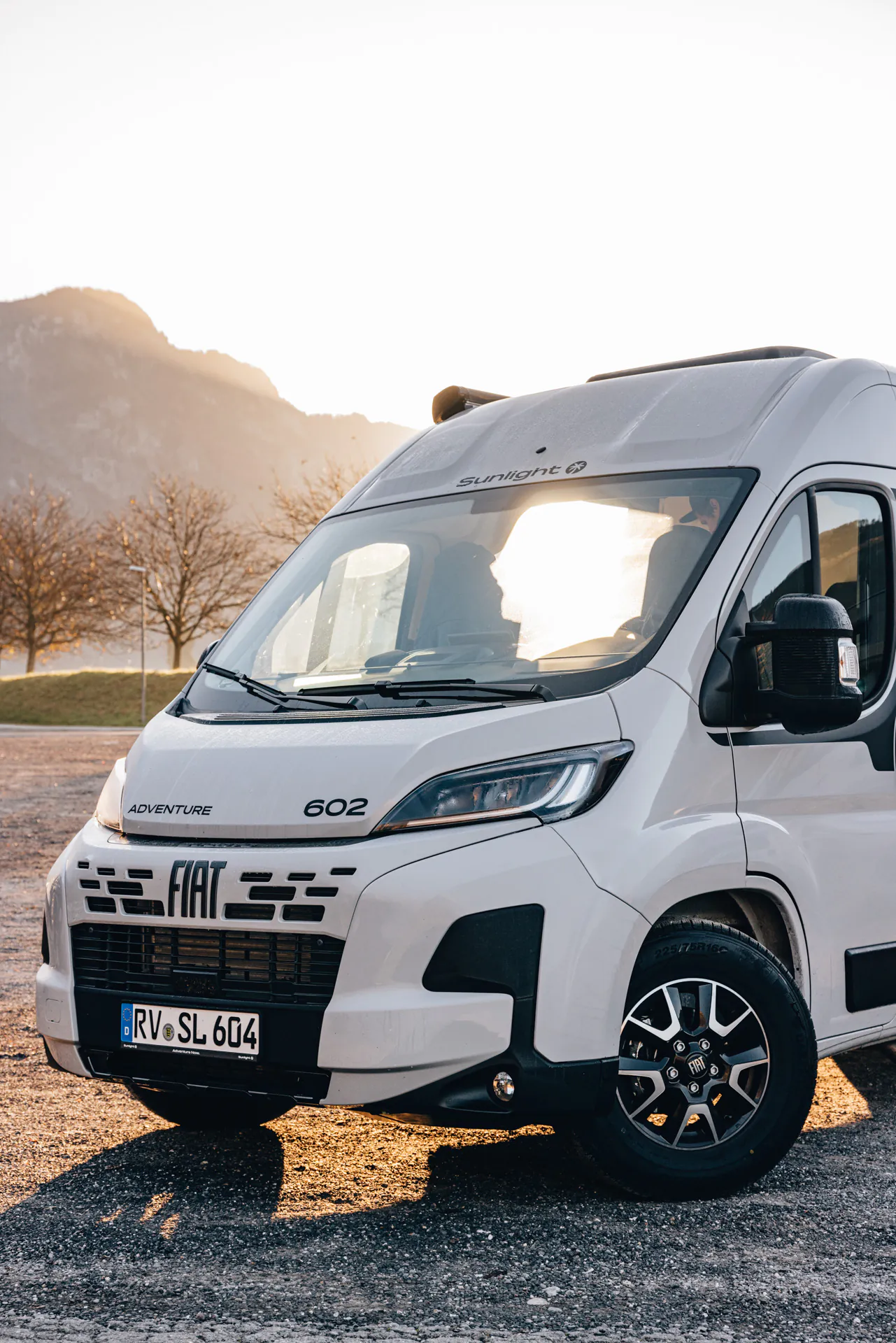 Wohnmobil Fiat Sunlight Adventure 602 vor Bergkulisse bei Sonnenuntergang.
