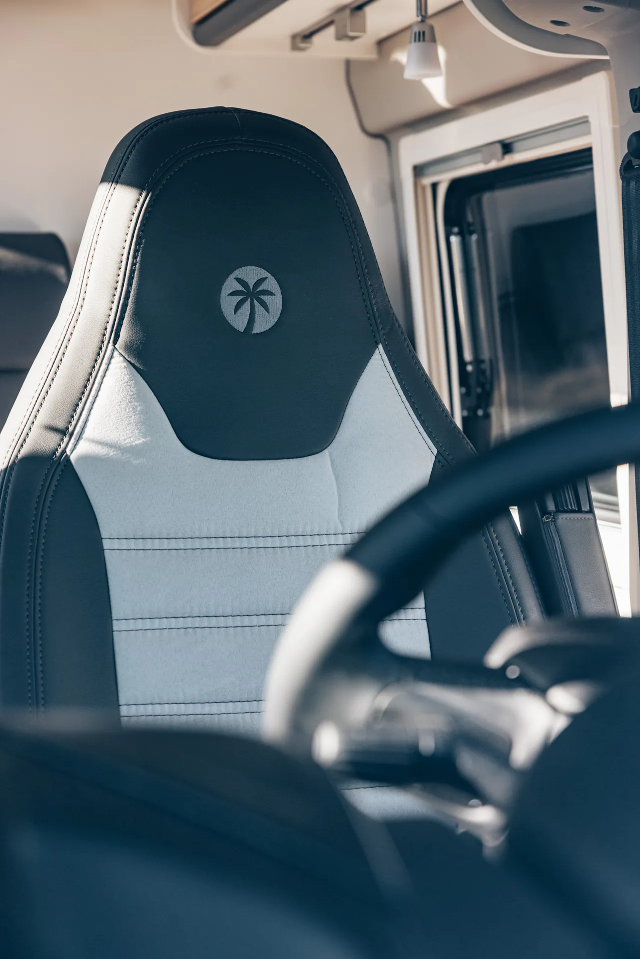 Sitz eines Campers mit Palmenlogo auf der Kopfstütze.