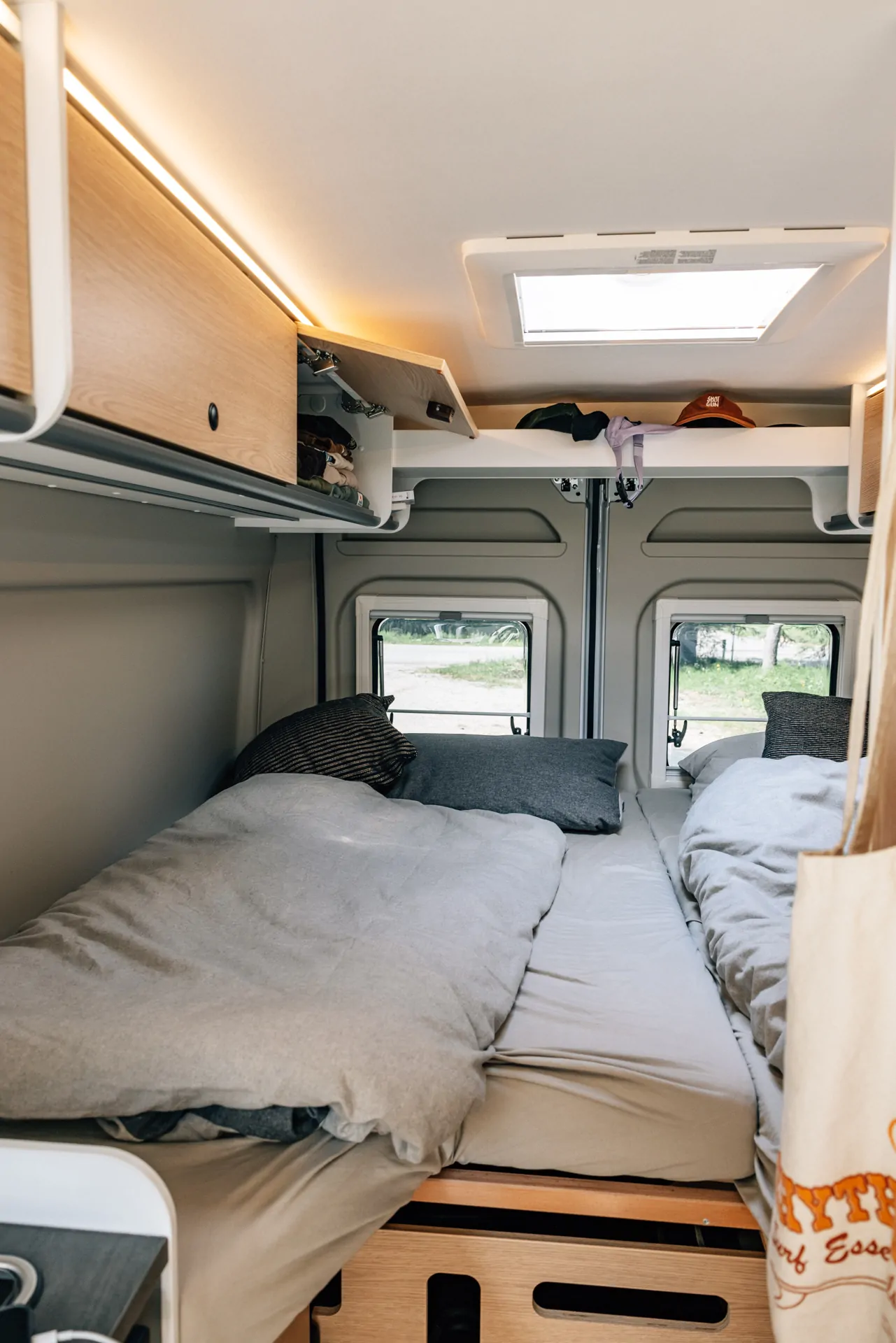 Innenansicht eines Sunlight Cliff X Campervans mit zwei Betten und Stauraum.