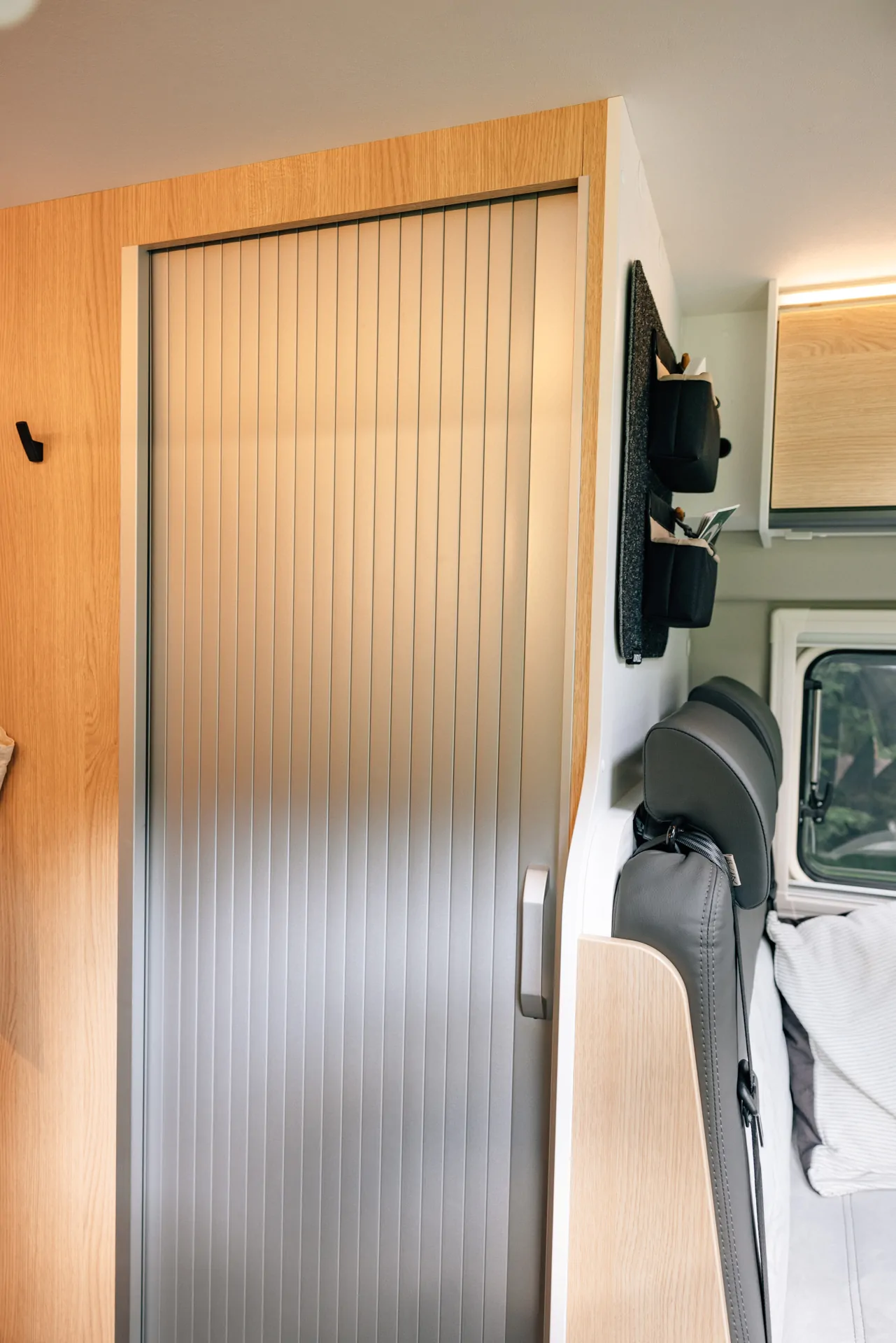 Innenansicht eines Sunlight Cliff X 2024 Campers mit Schiebetür und Sitzbank.