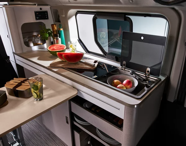 Innenansicht eines Bürstner Playa C500 Wohnmobils mit Küchenzeile, Wassermelonen und Äpfeln.