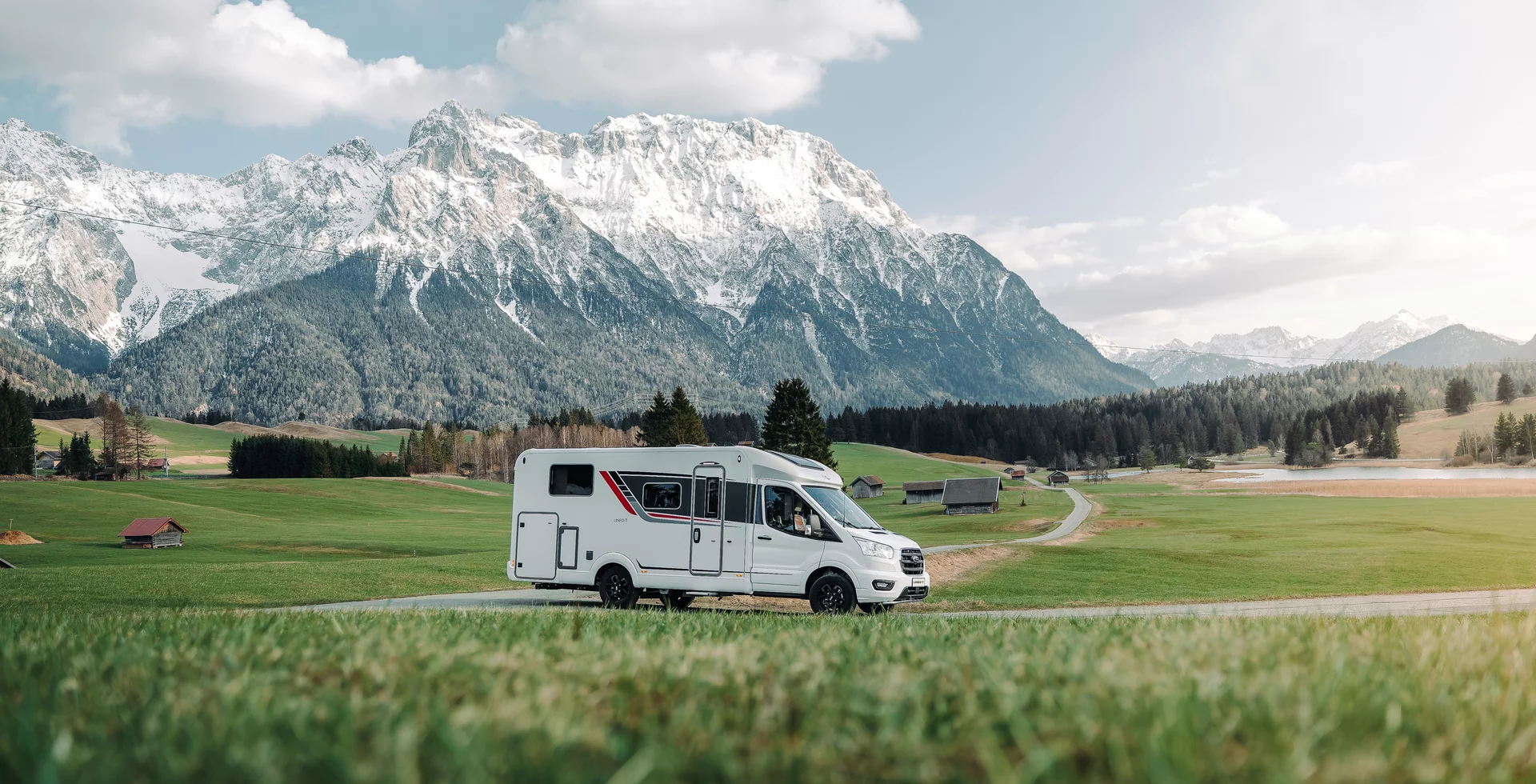 Wohnmobil Lineo T 690 vor einer malerischen Alpenlandschaft.