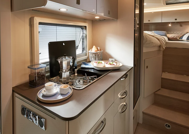 Innenansicht eines Lineot 690 Wohnmobils mit Küche und Schlafbereich.