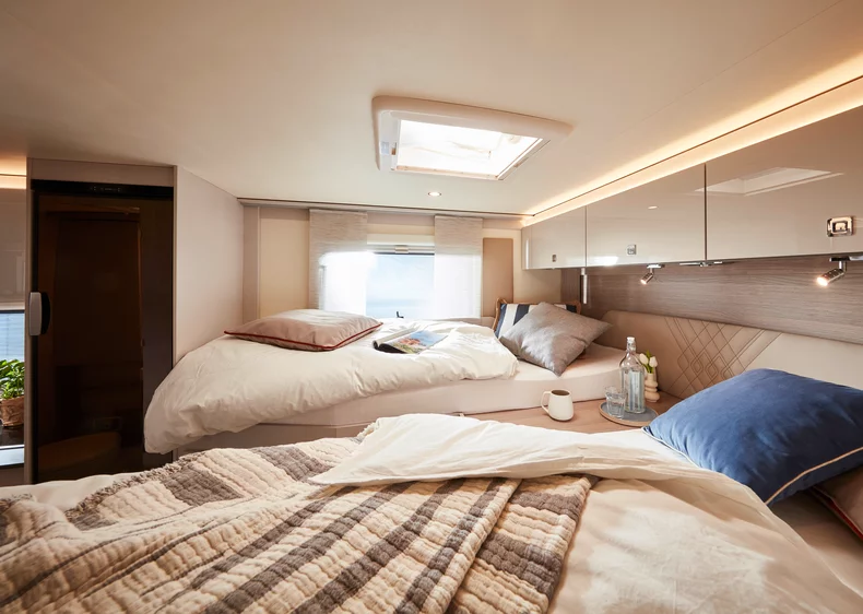 Innenansicht eines Lineot 690 Wohnmobils mit gemütlichem Doppelbett und Oberlichtern.