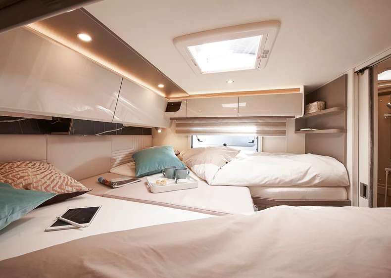 Innenraum eines Bürstner Lyseo I Wohnmobils mit gemütlichem Doppelbett und Dachfenster.