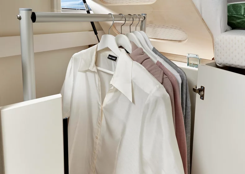 Kleiderstange mit mehreren aufgehängten Hemden in einem Wohnmobil.