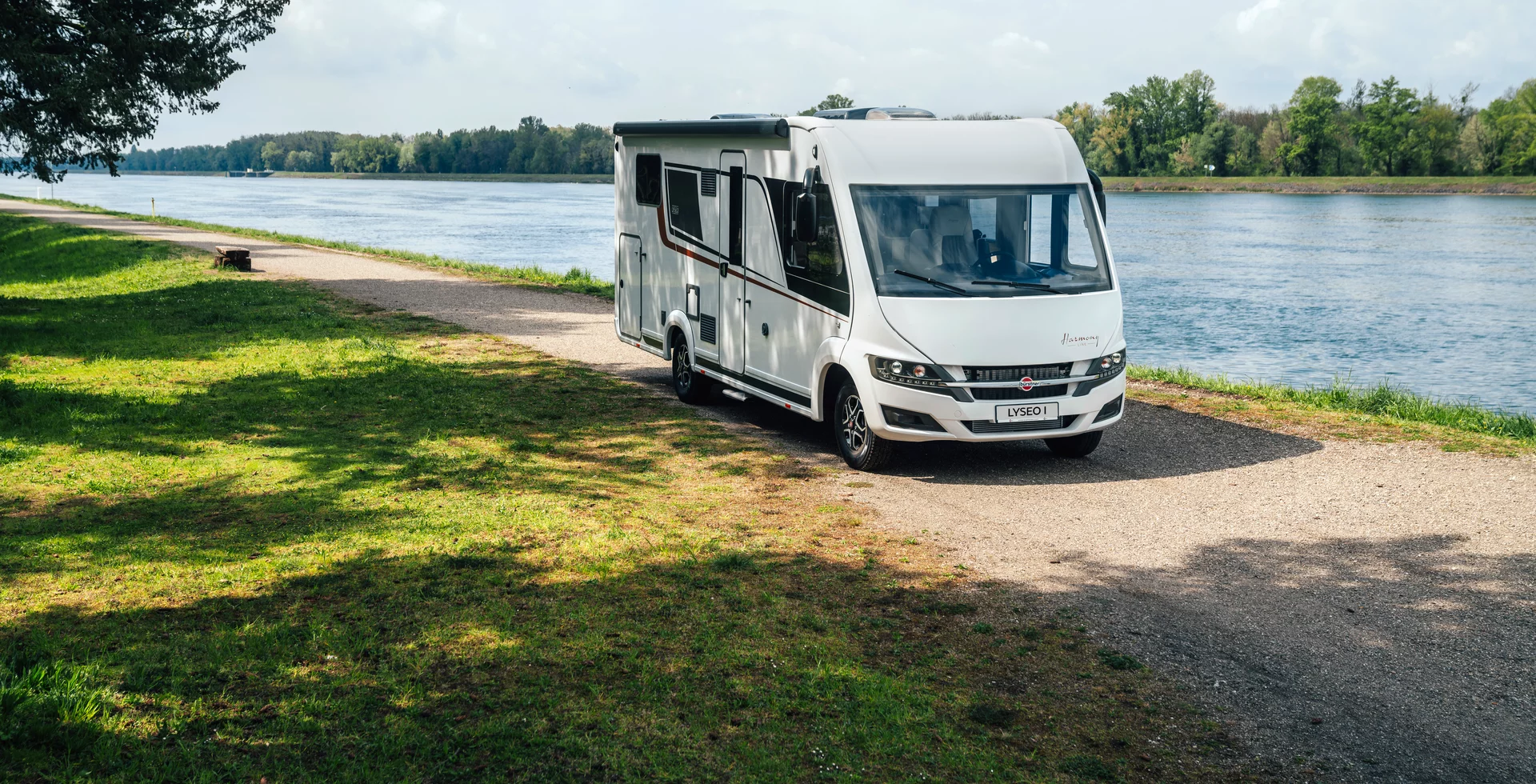 Wohnmobil Bürstner Lyseo fährt auf einem Weg entlang eines Flusses.
