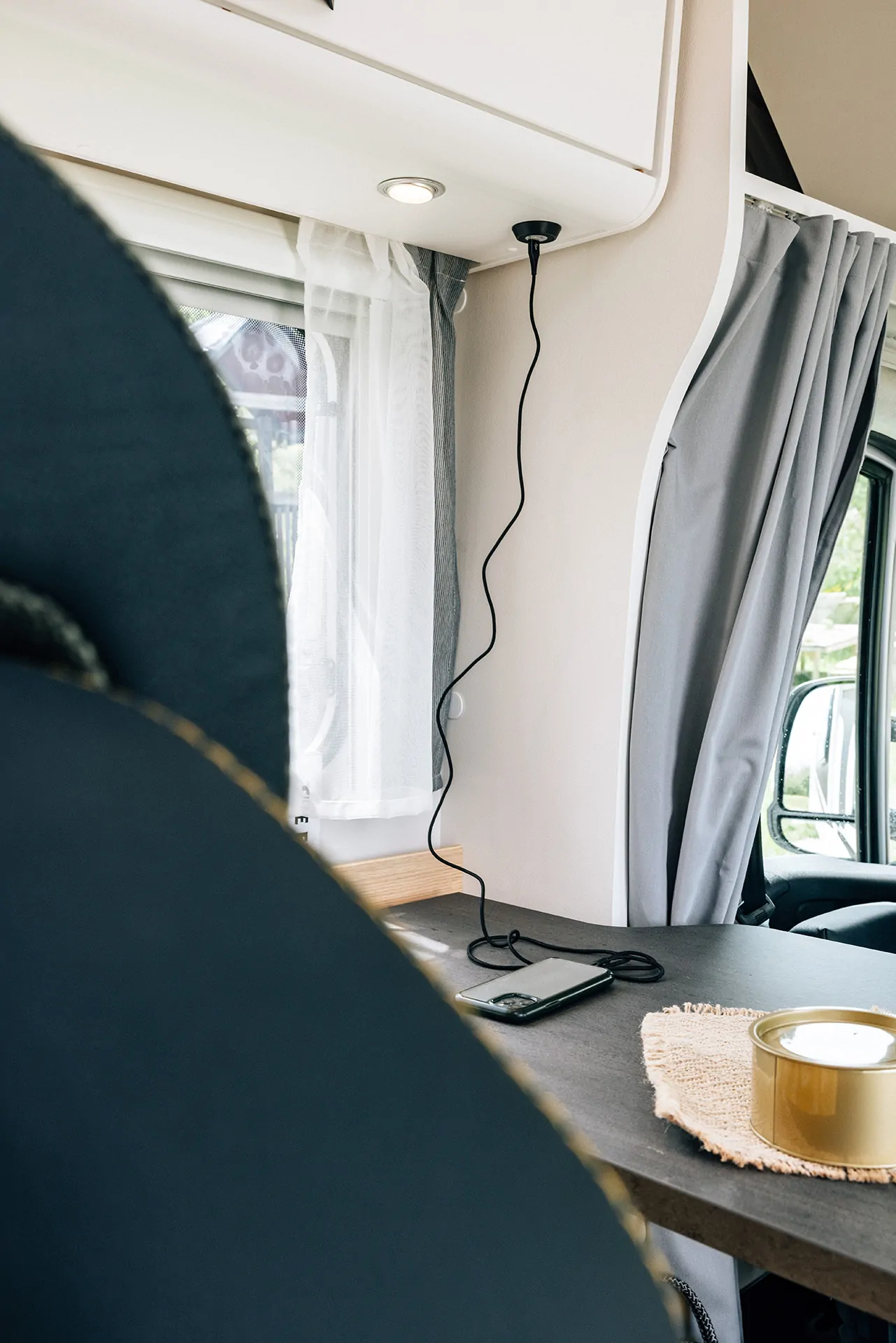 Ein Smartphone liegt auf einem Tisch in einem Alkoven-Wohnmobil.
