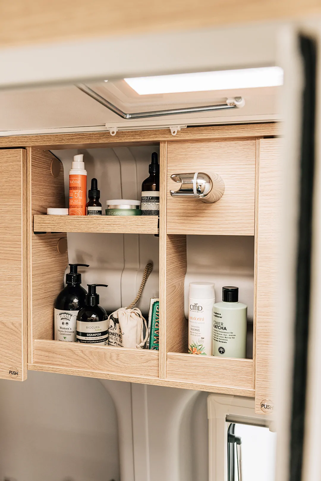 Holzschrank im Camper mit verschiedenen Pflegeprodukten auf Regalen.