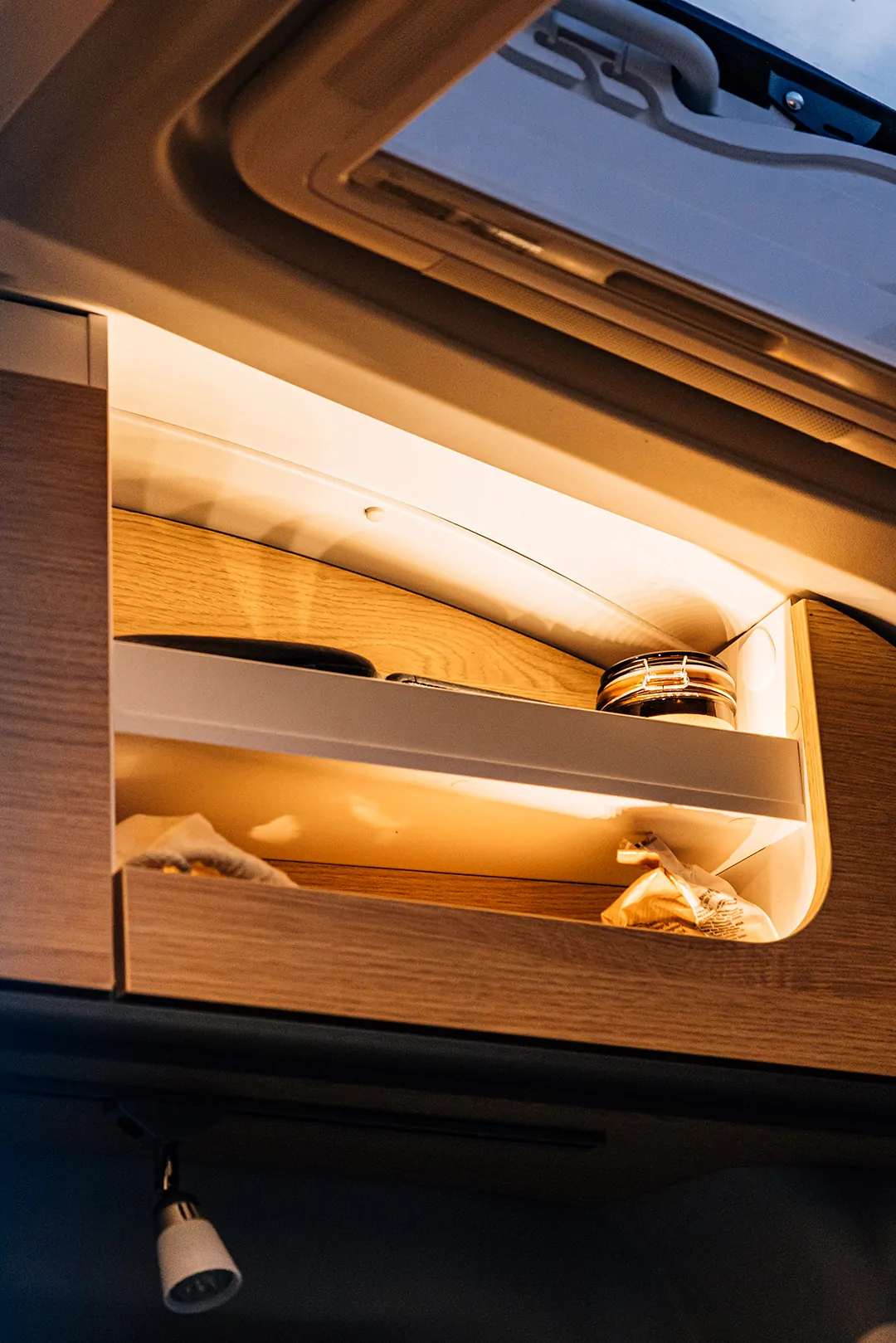 Offenes Ablagefach im Schlafbereich eines Cliff 4x4 Campers.