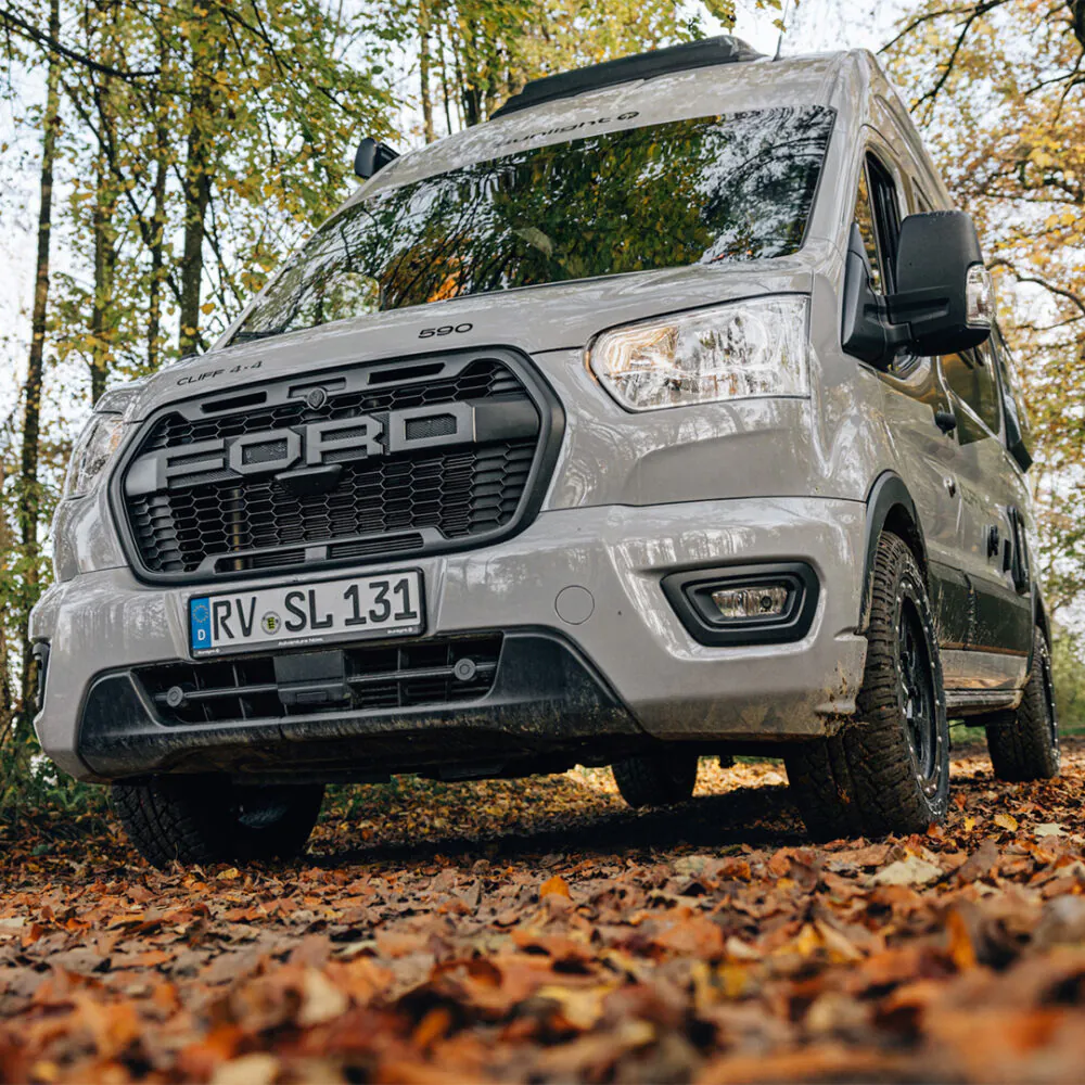 Ein Ford Campervan, Modell Cliff 4x4, steht im herbstlichen Wald.