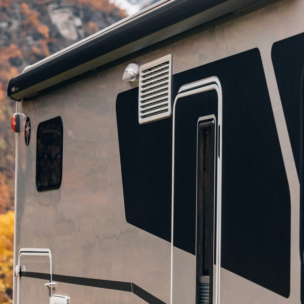 Seitenansicht eines Wohnmobils mit markanten schwarzen Grafiken.