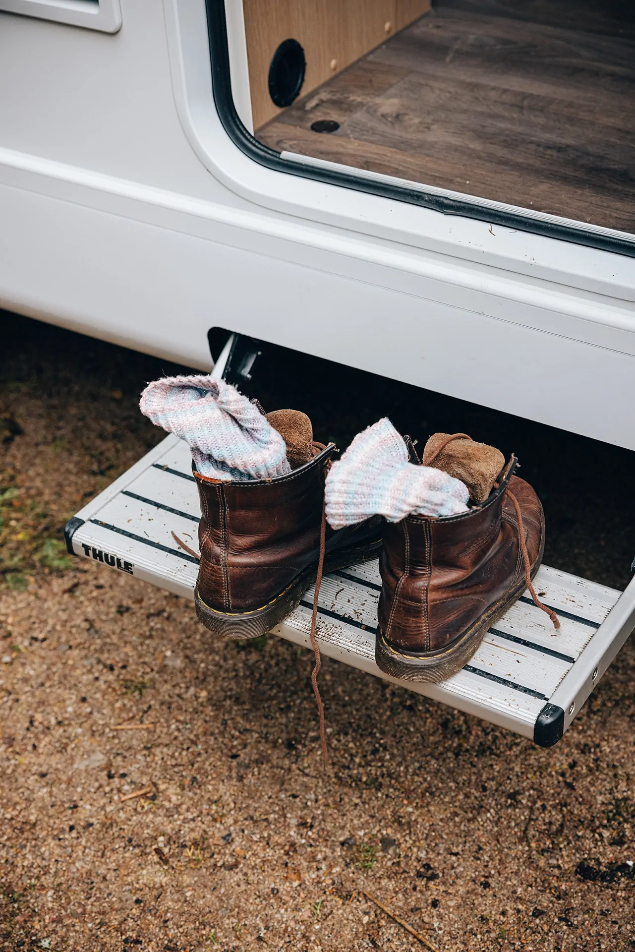 Ein Paar braune Stiefel mit Socken steht auf der Einstiegstufe eines Sunlight Vans.
