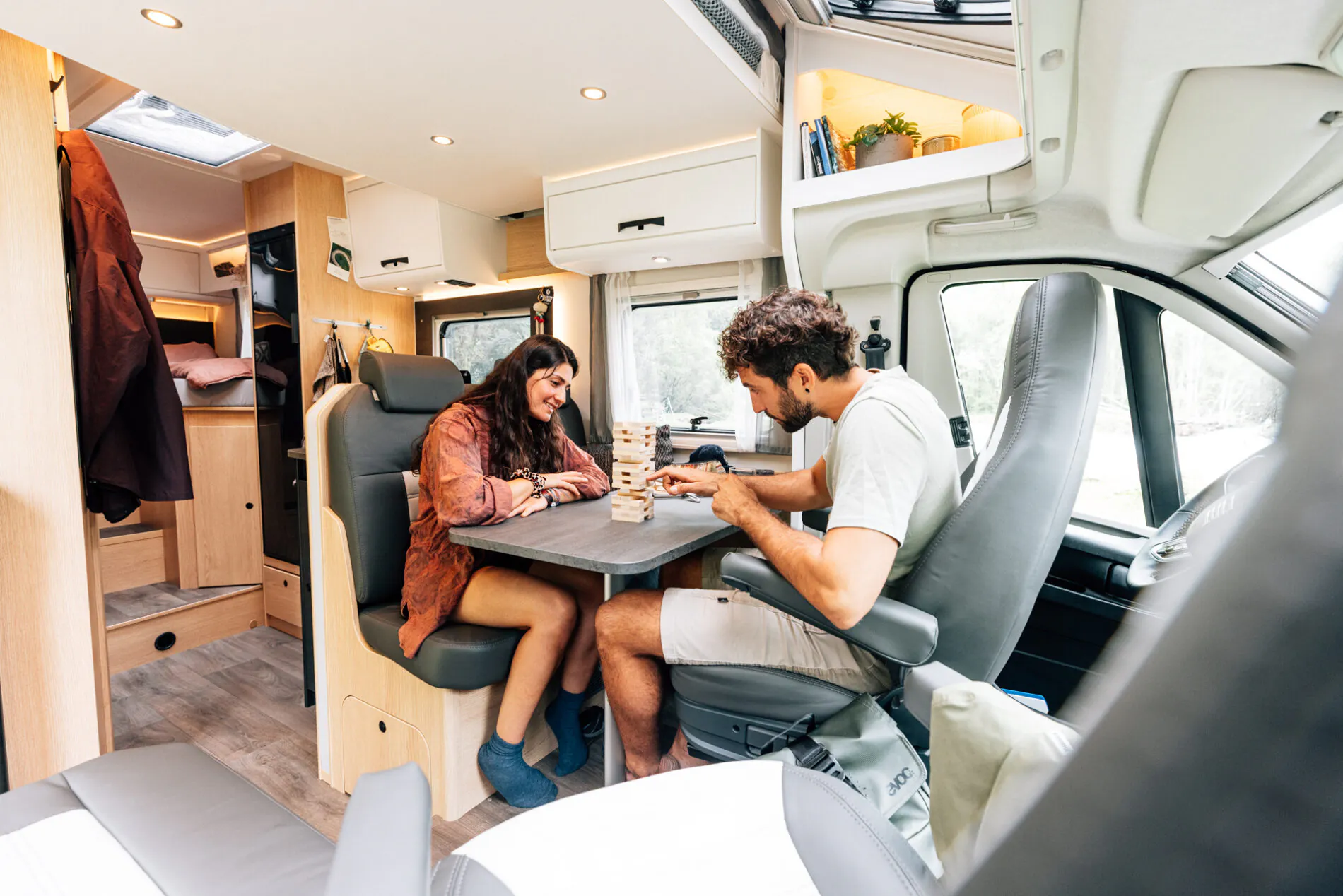 Zwei Personen spielen ein Spiel im Inneren eines teilintegrierten Wohnmobils.