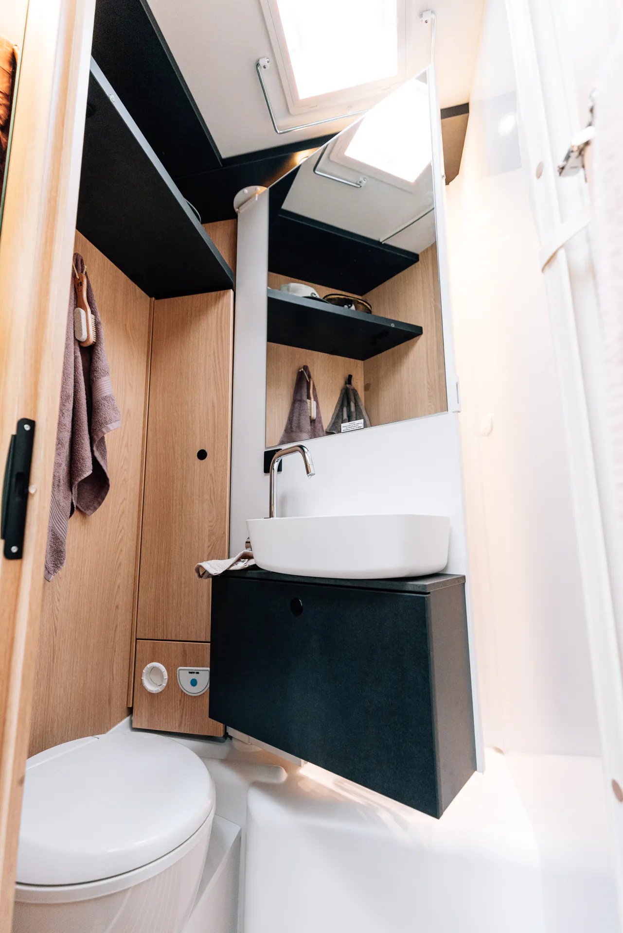 Kompaktes Badezimmer mit Waschbecken und Toilette in einem Wohnmobil.