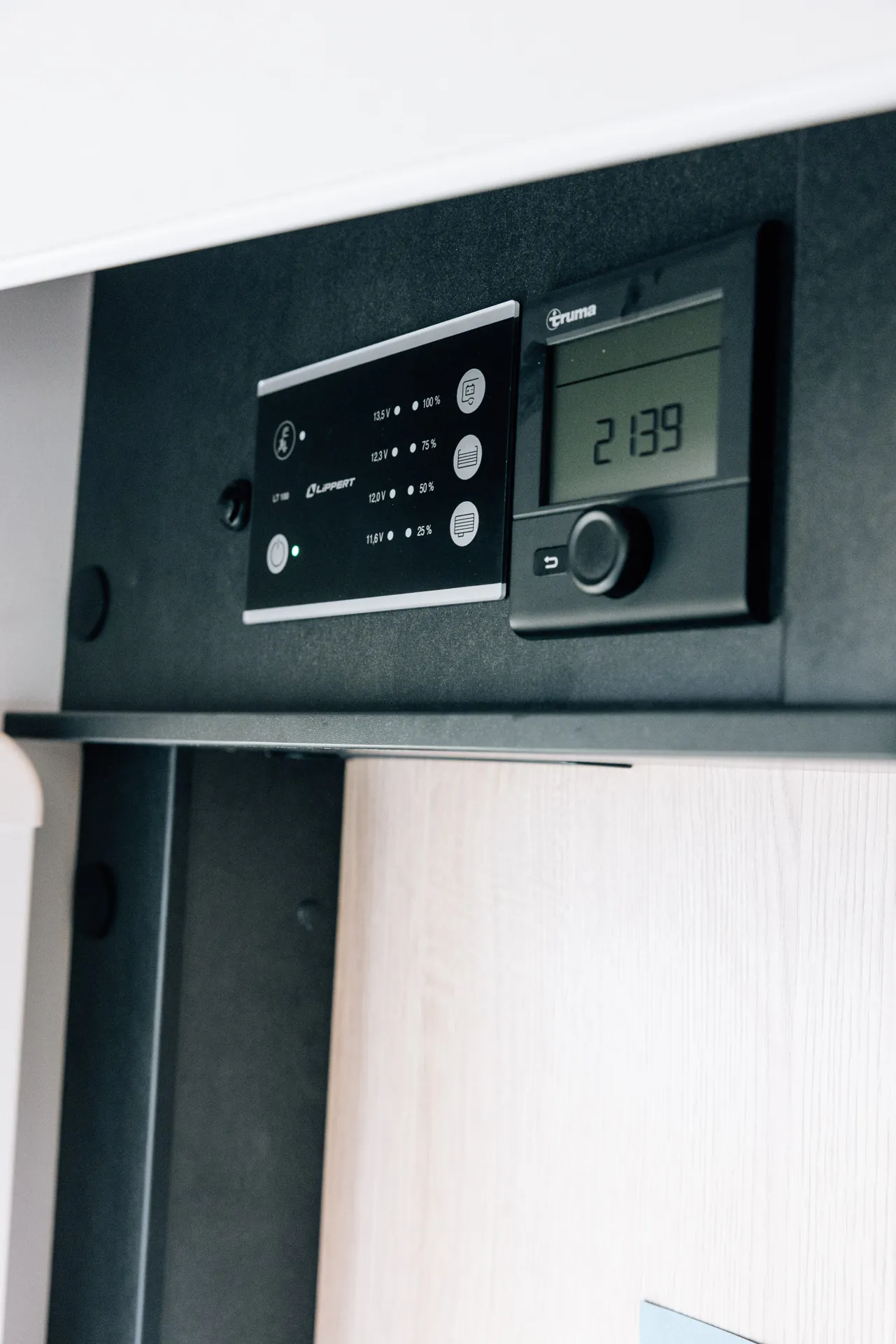 Bedienfeld eines Wohnmobils mit digitalen Anzeigen und Knöpfen.