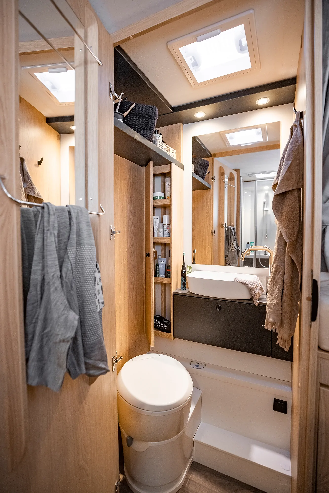 Interieur eines Ford Adventure Wohnmobils mit Bad, Waschbecken und Stauraum.