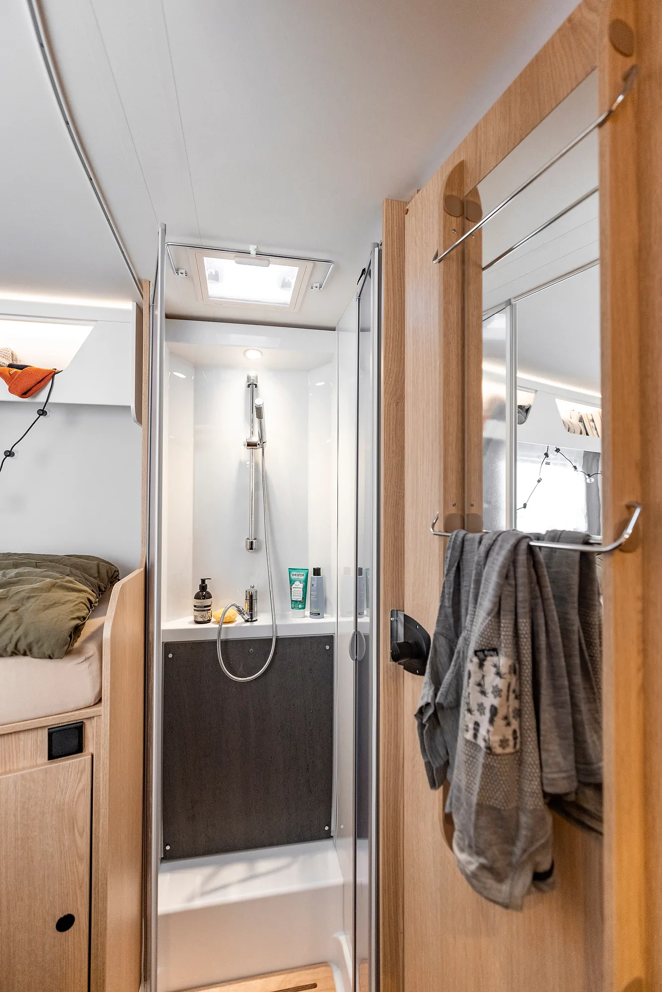Duschbereich im Ford Adventure Wohnmobil mit Handtüchern und Pflegeprodukten.