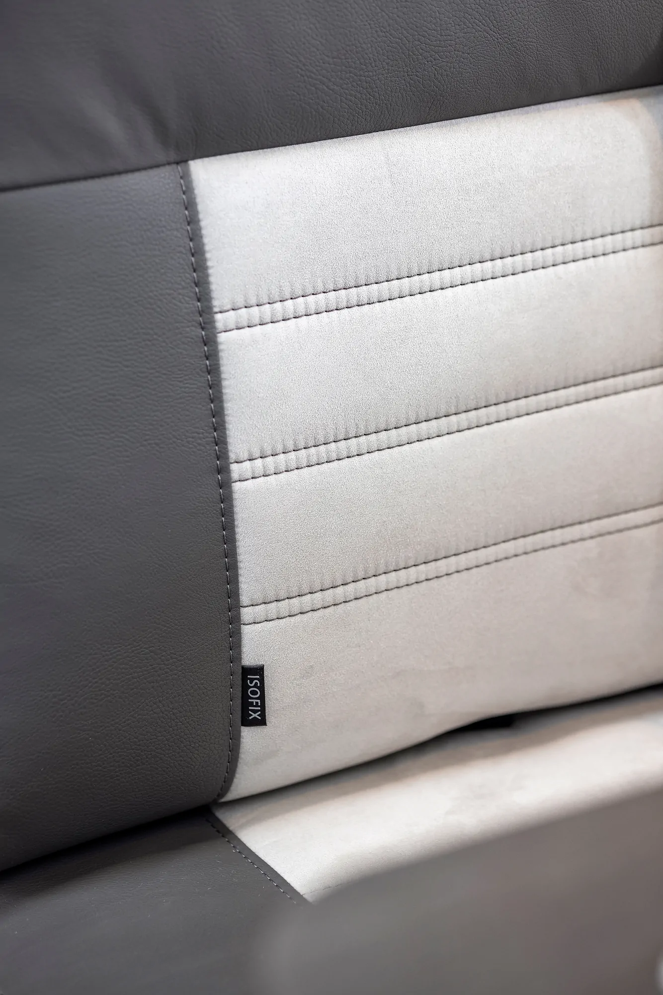 Nahaufnahme eines zweifarbigen Autositzes mit ISOFIX-Befestigung.