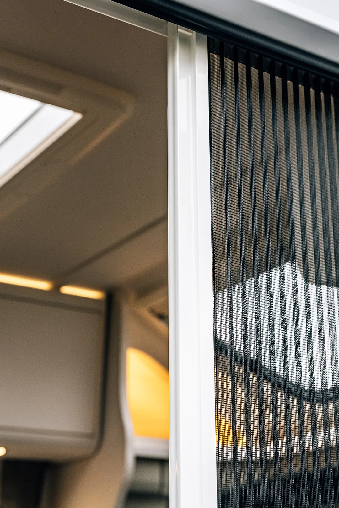 Teilintegrierter Ford Adventure Camper mit geöffneter Tür und Insektenschutznetz.