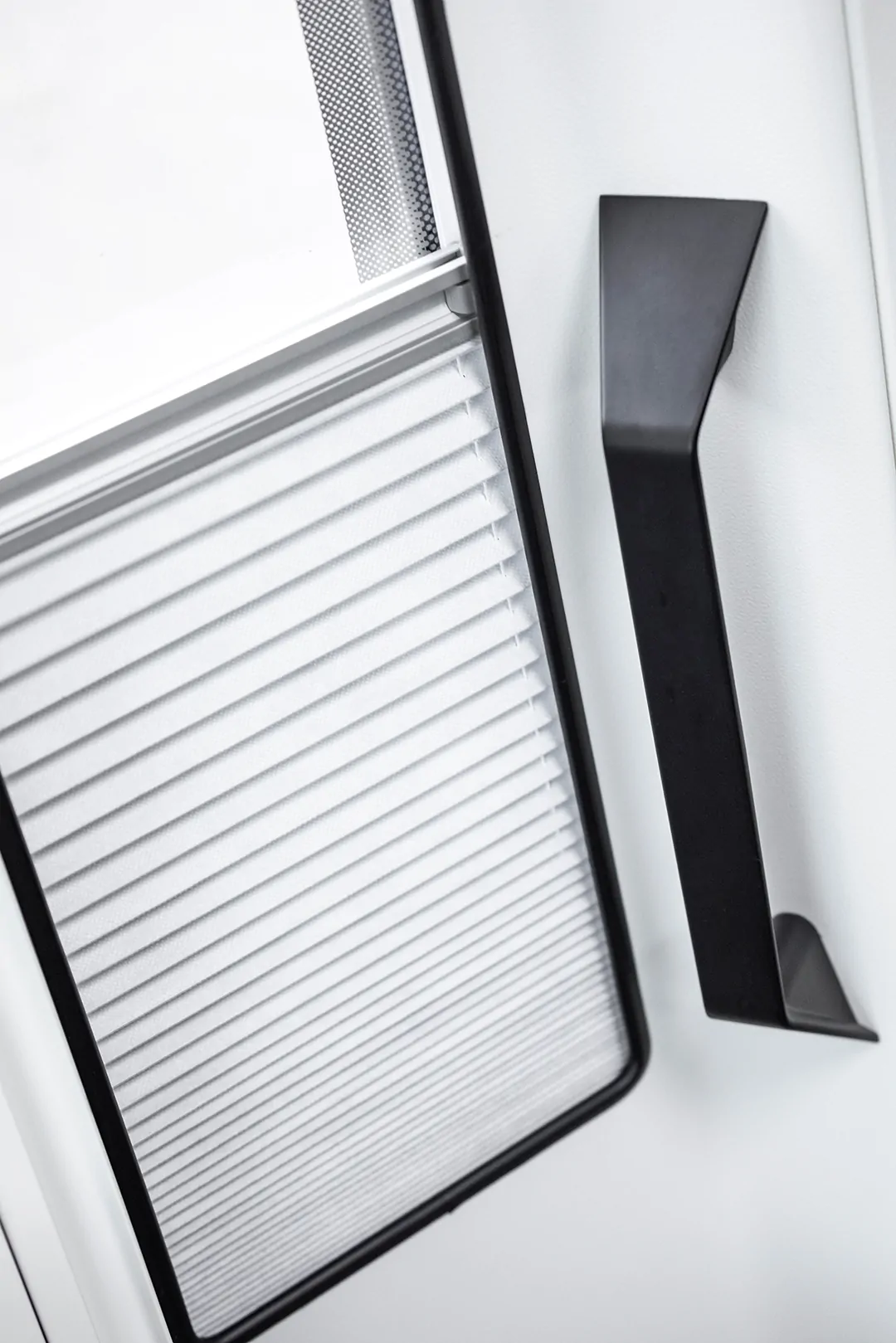 Türgriff und Jalousie eines Fahrzeugs, vermutlich eines Ford Adventure Wohnmobils.