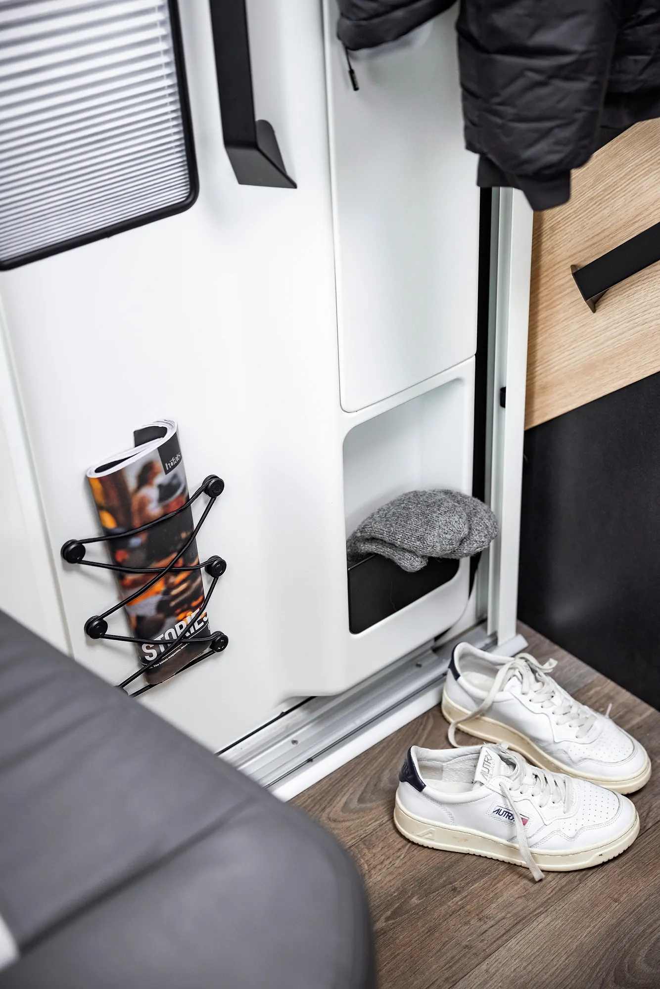 Weiße Sneakers und eine graue Mütze in einem Wohnmobil, vermutlich Ford Adventure.