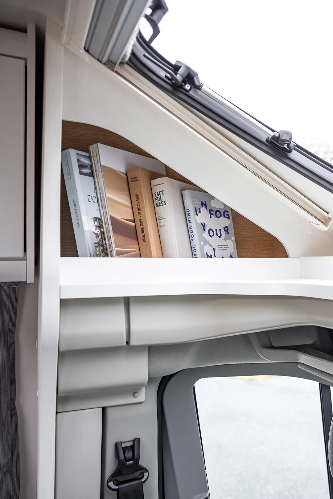 Bücherregal im Ford Adventure Wohnmobil mit mehreren Büchern.