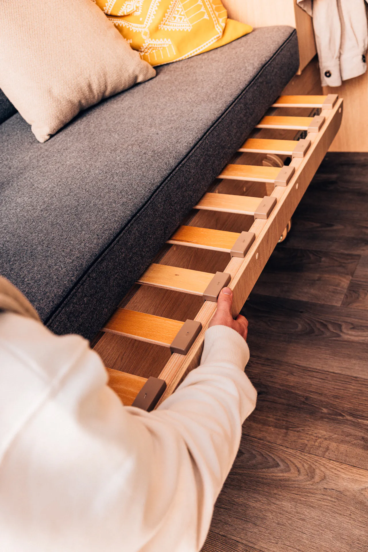 Person zieht ein ausziehbares Bettgestell in einem Van heraus.