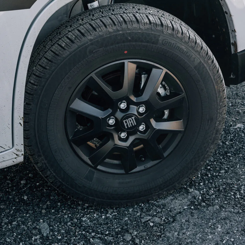 Nahaufnahme eines Fiat-Rads auf Kies.