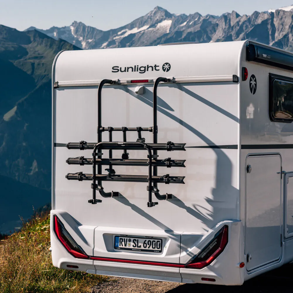 Wohnmobil Sunlight mit Fahrradträger vor Bergkulisse.