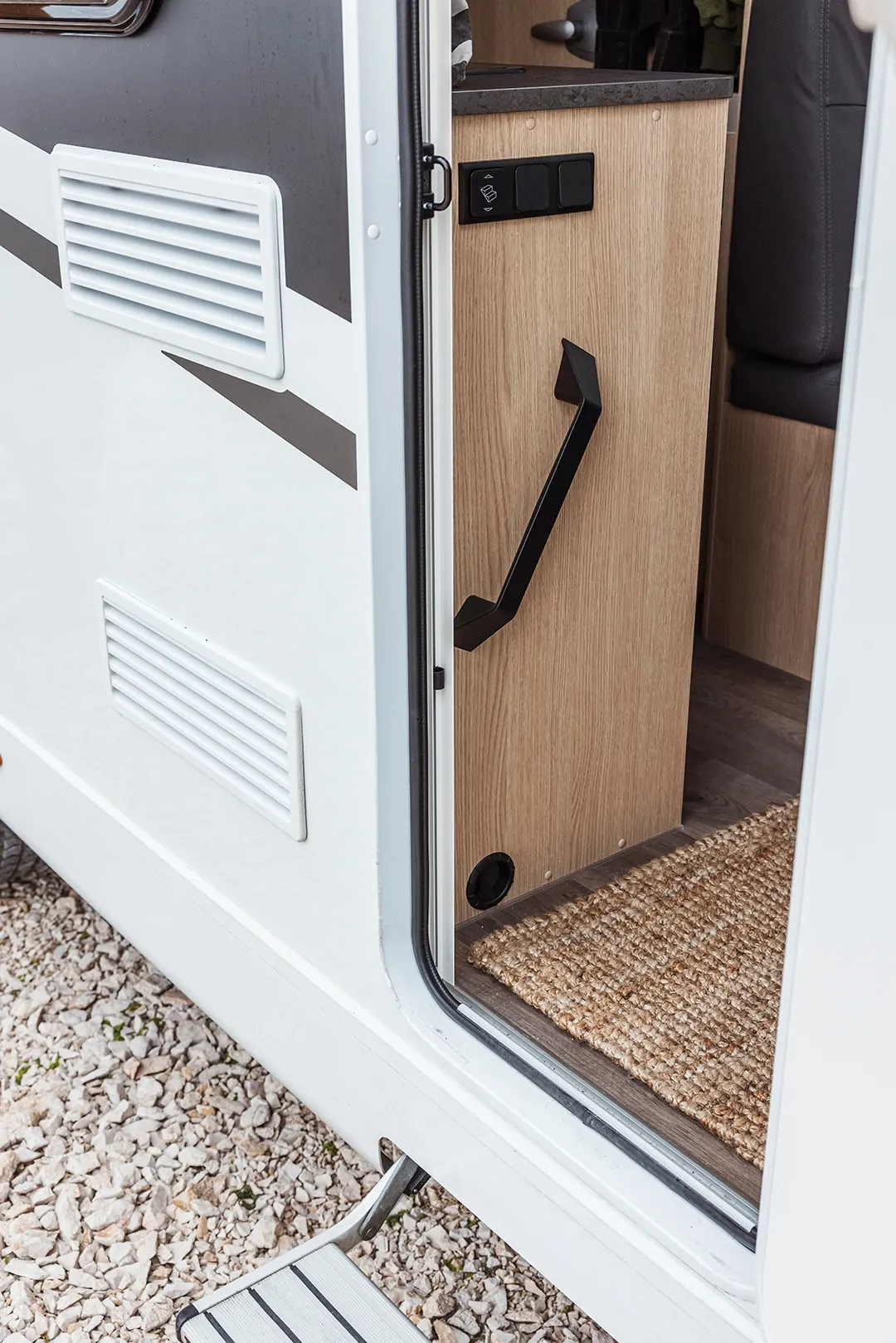 Eingang eines Wohnmobils mit offener Tür und Blick auf den Innenraum.