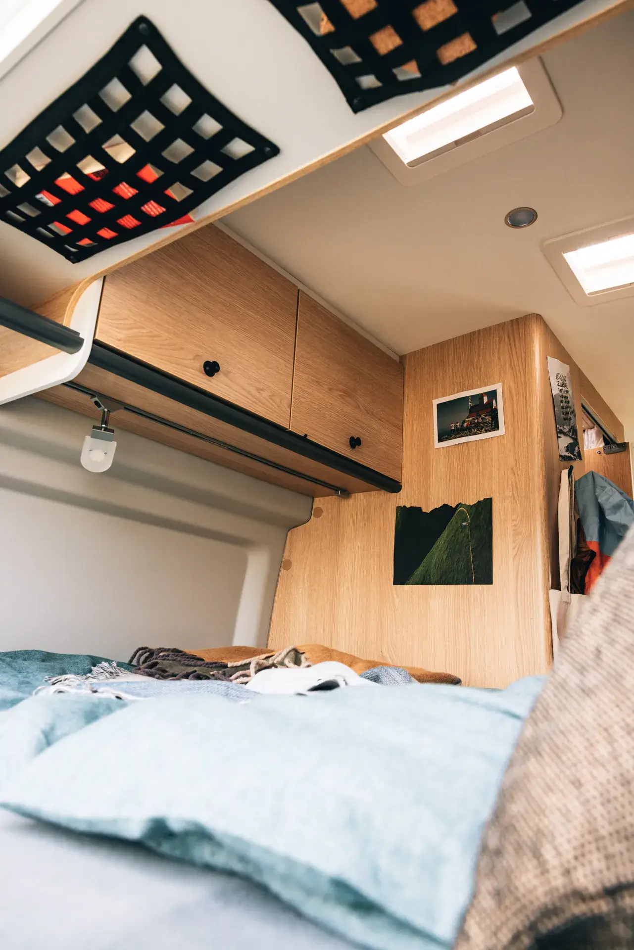 Innenraum eines Sunlight-Campers mit Holzschränken und Bett.