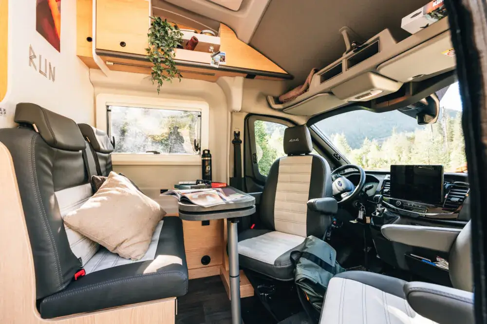 Innenansicht eines Sunlight-Greentrek-Campers mit Sitzbereich und Tisch.