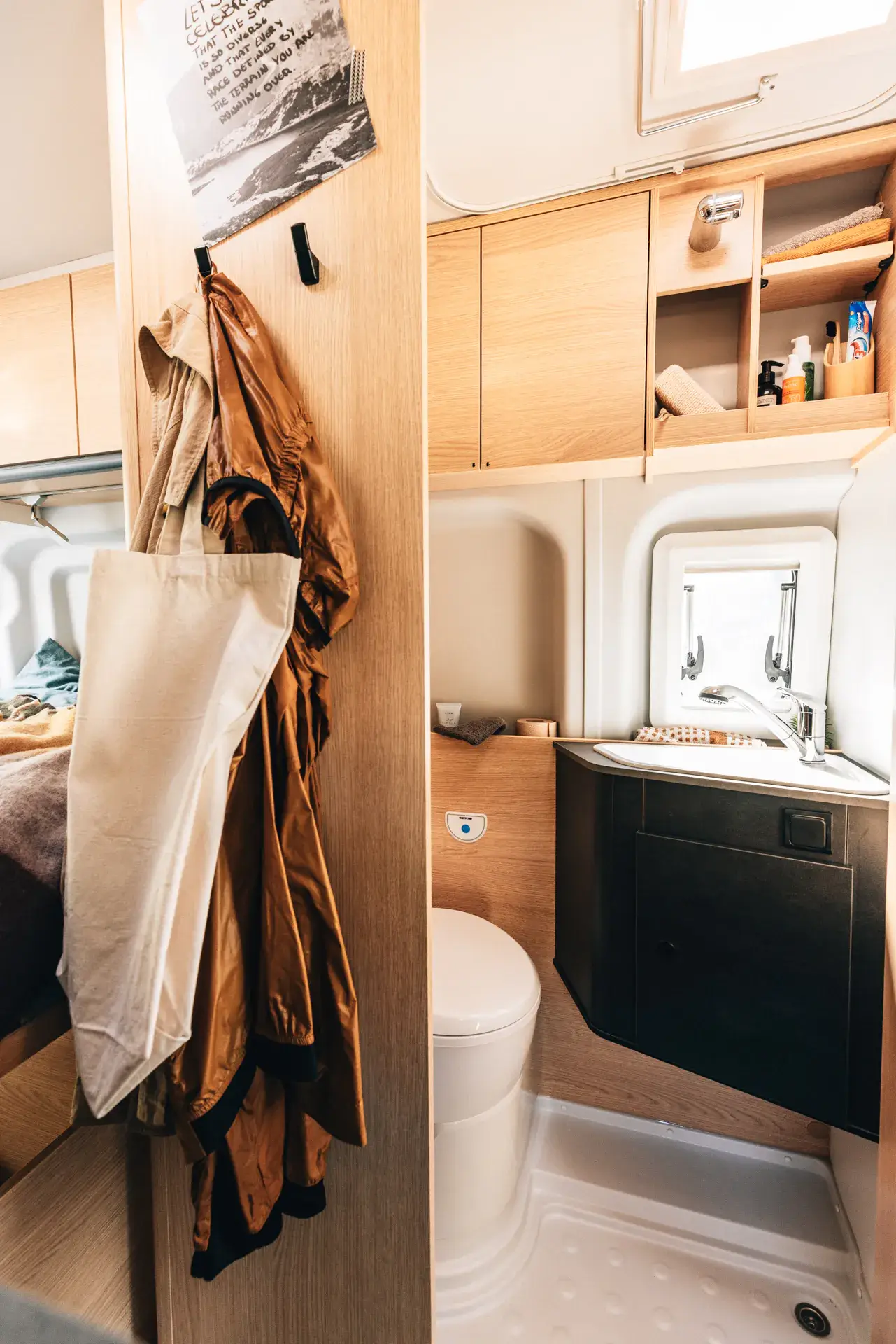 Innenansicht eines Sunlight-Campers mit Bad und Haken für Kleidung.
