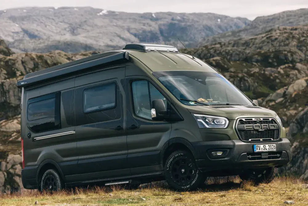 Grüner Ford Sunlight 4x4 Greentrek in bergiger Landschaft.